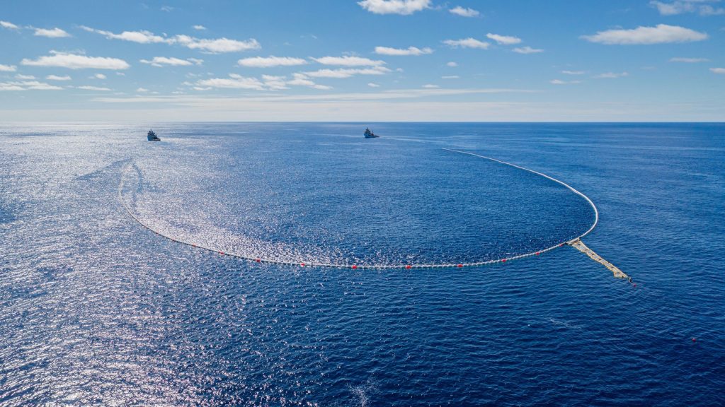 Grande rede de coleta de lixo no oceano, puxada por dois navios